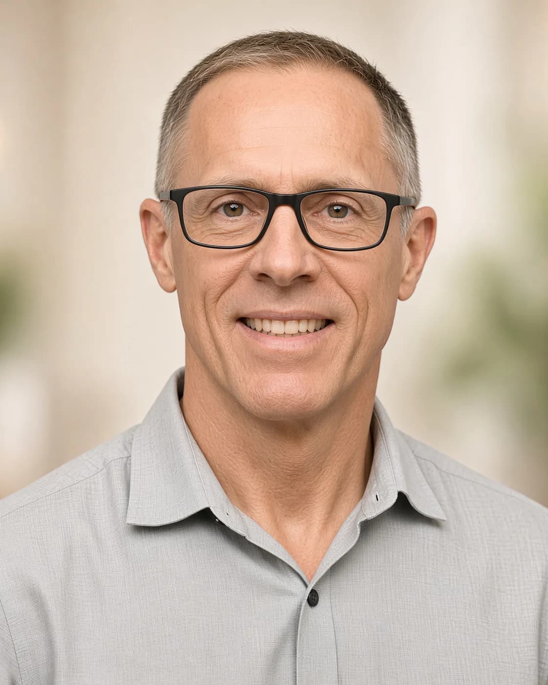Courtland Keith, D.C., indoors, wearing glasses and a light gray button-down.
